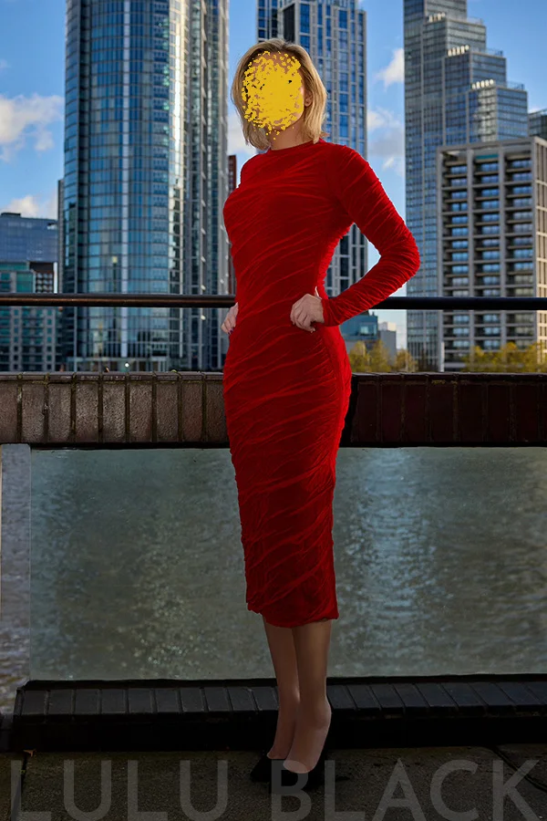 Robin modelling a red dress, stood on the balcony of her North West home.