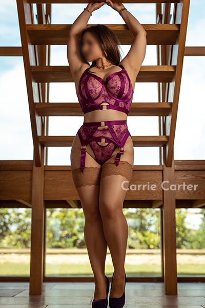 Carrie Carter in cerise pink lingerie, standing in a Wiltshire home.